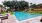 a swimming pool with trees and flowers around it